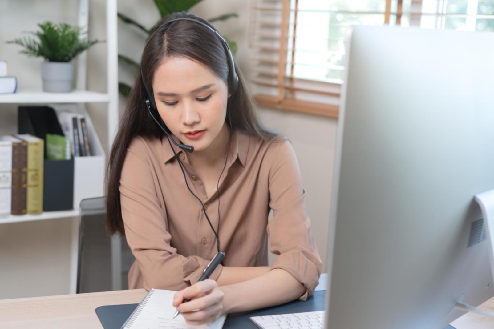Persona revisando cuidadosamente documentos financieros y calculadoras
